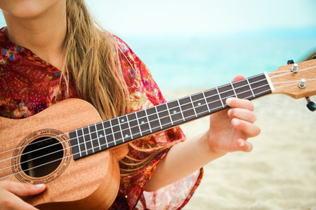happy child playing guitar by the sea greece on nature backgroundの写真素材