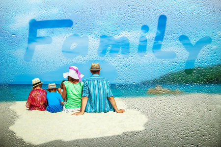 Happy family at the sea in Greece on a background of nature through wet glassの写真素材