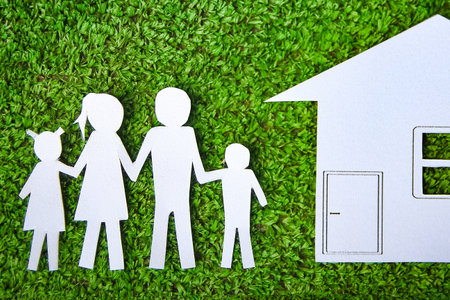 Paper family with a house on a background of grassの写真素材