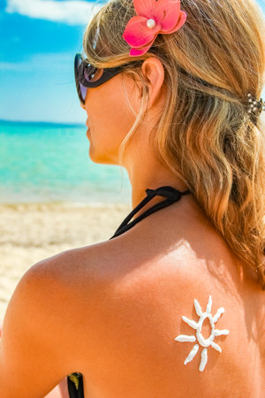 happy girl on the sea with a picture of the sun on her back