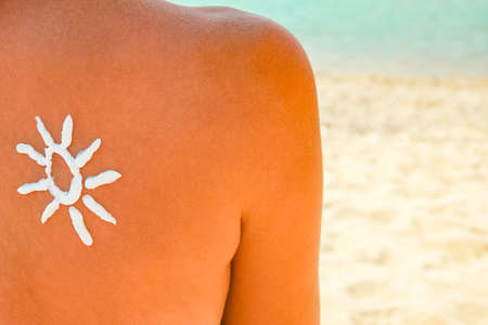 happy girl on the sea with a picture of the sun on her backの写真素材
