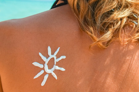 happy girl on the sea with a picture of the sun on her back