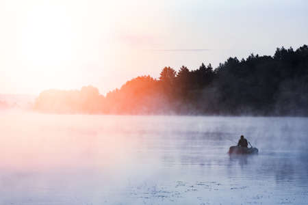 fisherman on the river in the fog in the park on the natureの写真素材