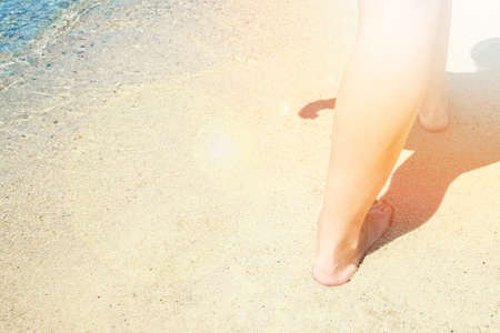 beautiful legs on the sand by the seaの写真素材