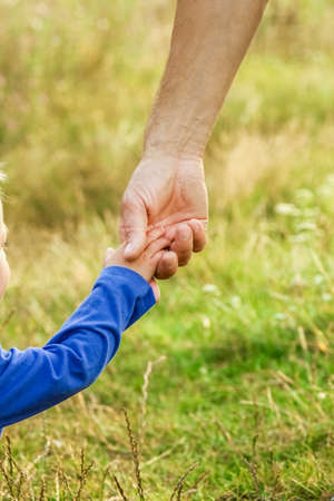 hands of parent and child in nature