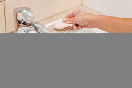 Washing hands with soap under the faucet with water