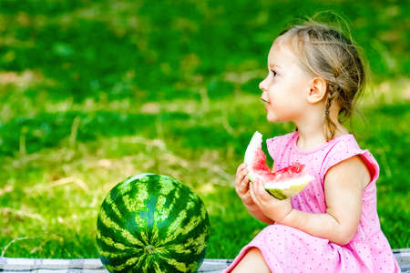 happy child with watermelon on nature in the parkの写真素材