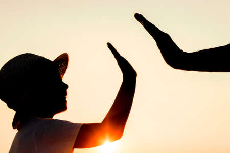 Hands of happy father and child by the sea on nature silhouette travel