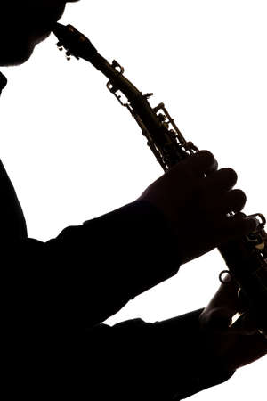 saxafon on a white background in the hands of a musician silhouetteの写真素材