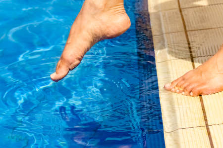 beautiful legs of a girl near a swimming pool on the sea backgroundの写真素材