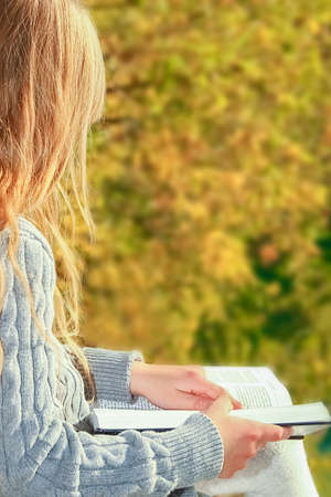 Happy child reading book on nature education in park travel
