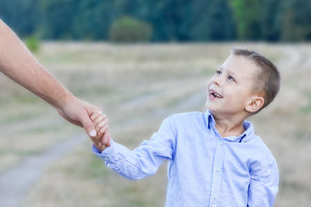 Happy child and parent's hands on nature in the park travelの写真素材