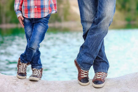 Feet of happy parent and child in nature in the park travelの写真素材