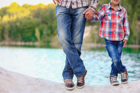 Feet of happy parent and child in nature in the park travelの写真素材