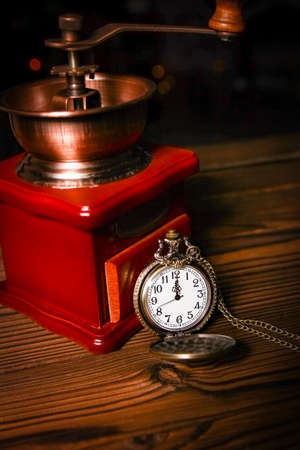 pocket watch with a coffee grinder on a wooden backgroundの写真素材