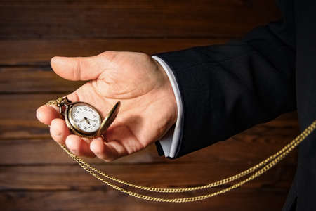 pocket watch in the hands of a manの写真素材