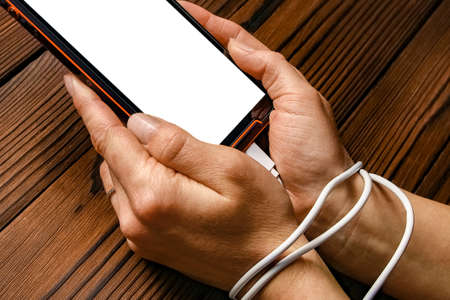 phone with hands addiction on a wooden background