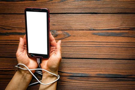 phone with hands addiction on a wooden background