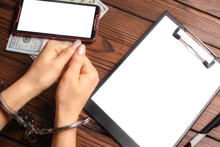 phone with hands and money corruption on a wooden backgroundの写真素材