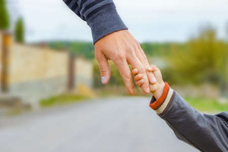beautiful hands of parent and child outdoors in the park