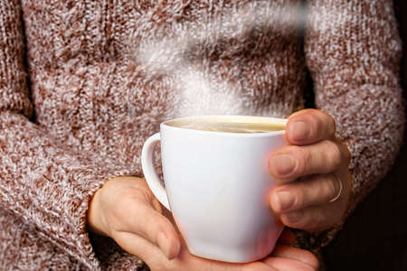 female hands and coffee on wooden background