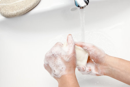 Hands with soap are washed under the tap with water. Clean from infection and dirt and virus. At...