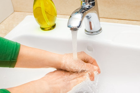 Hands with soap are washed under the tap with water. Clean from infection and dirt and virus. At...