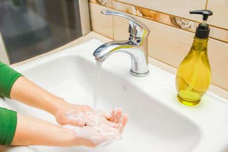 Hands with soap are washed under the tap with water. Clean from infection and dirt and virus. At...