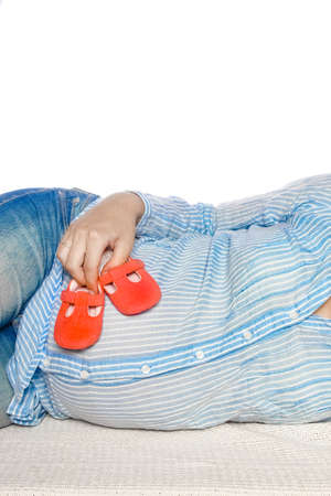 Happy pregnant girl lies on white backgroundの写真素材