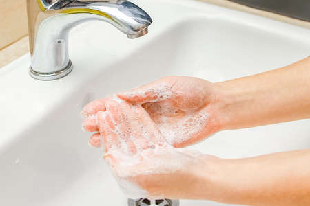 Hands with soap are washed under the tap with water. Clean from infection and dirt and virus. At...
