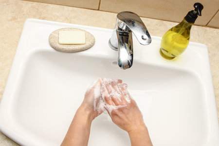 Washing hands with soap under the faucet with waterの写真素材
