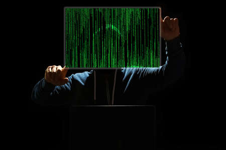 Hacker with laptop and abstract binary code.