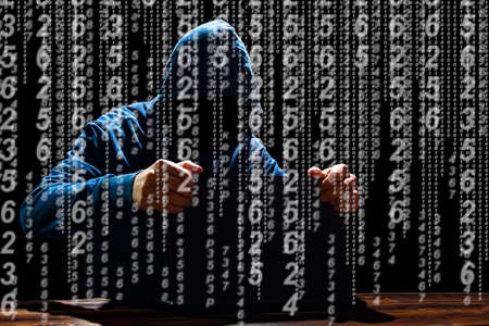 Hacker with laptop and abstract binary code.
