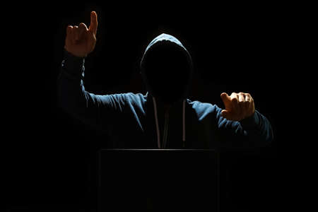 hacker with laptop on black background