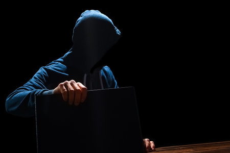 Hacker with laptop sits at a table and abstract binary code. Business life threat virtual programs.の写真素材
