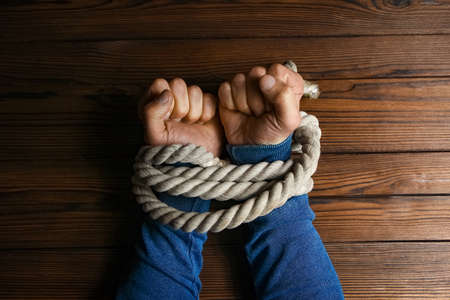 hands with a rope on a wooden backgroundの写真素材