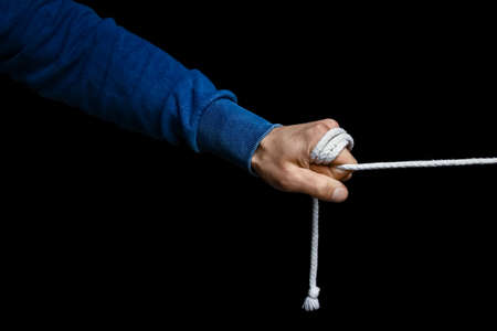 hands with a rope on a black backgroundの写真素材