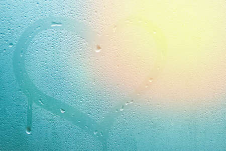 heart painted on glass window with drops background