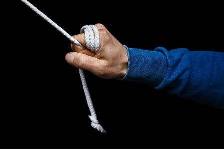 hands with a rope on a black backgroundの写真素材