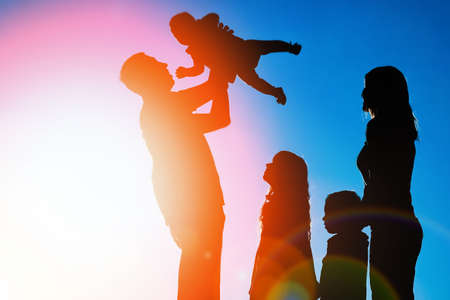 happy family outdoors in the park silhouetteの写真素材