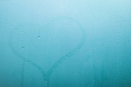 heart painted on glass window with drops backgroundの写真素材