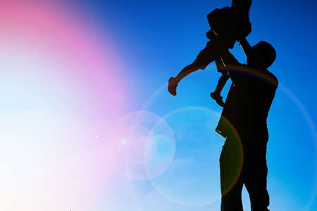 happy parent with child in the park outdoors silhouetteの写真素材