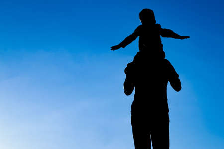 happy parent with child in the park outdoors silhouetteの写真素材