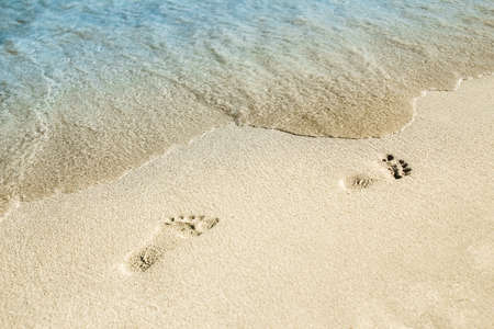 beautiful footprints with feet on the sand background