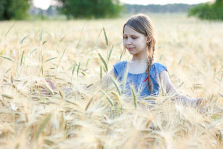 cute girl with spikelets of wheatの写真素材