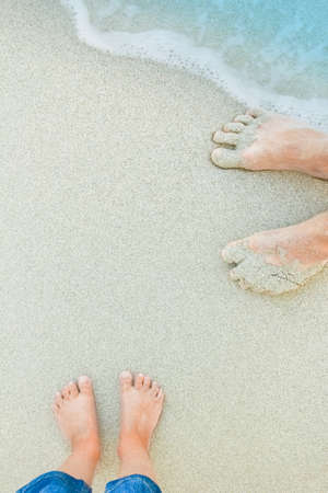 beautiful legs on sand near the sea on nature backgroundの写真素材
