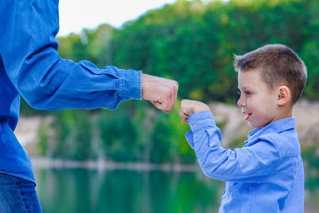 Hands of parent and child in nature in the park travelの写真素材