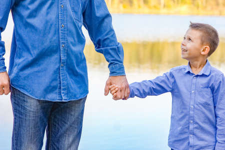 Hands of parent and child in nature in the park travel