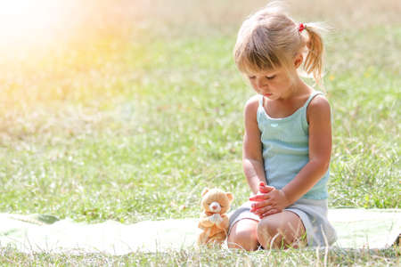 happy little girl praying in nature in the nature parkの写真素材