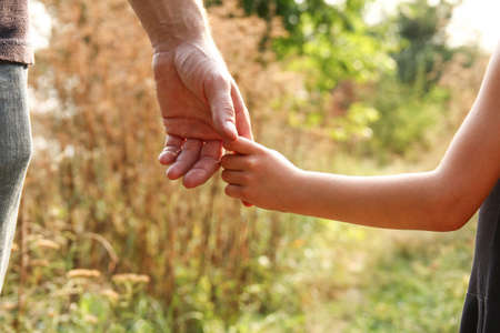 the parent holds the hand of a small childの写真素材